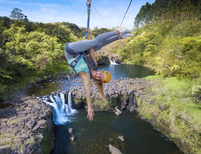 zip lining over a waterfall in hawaii