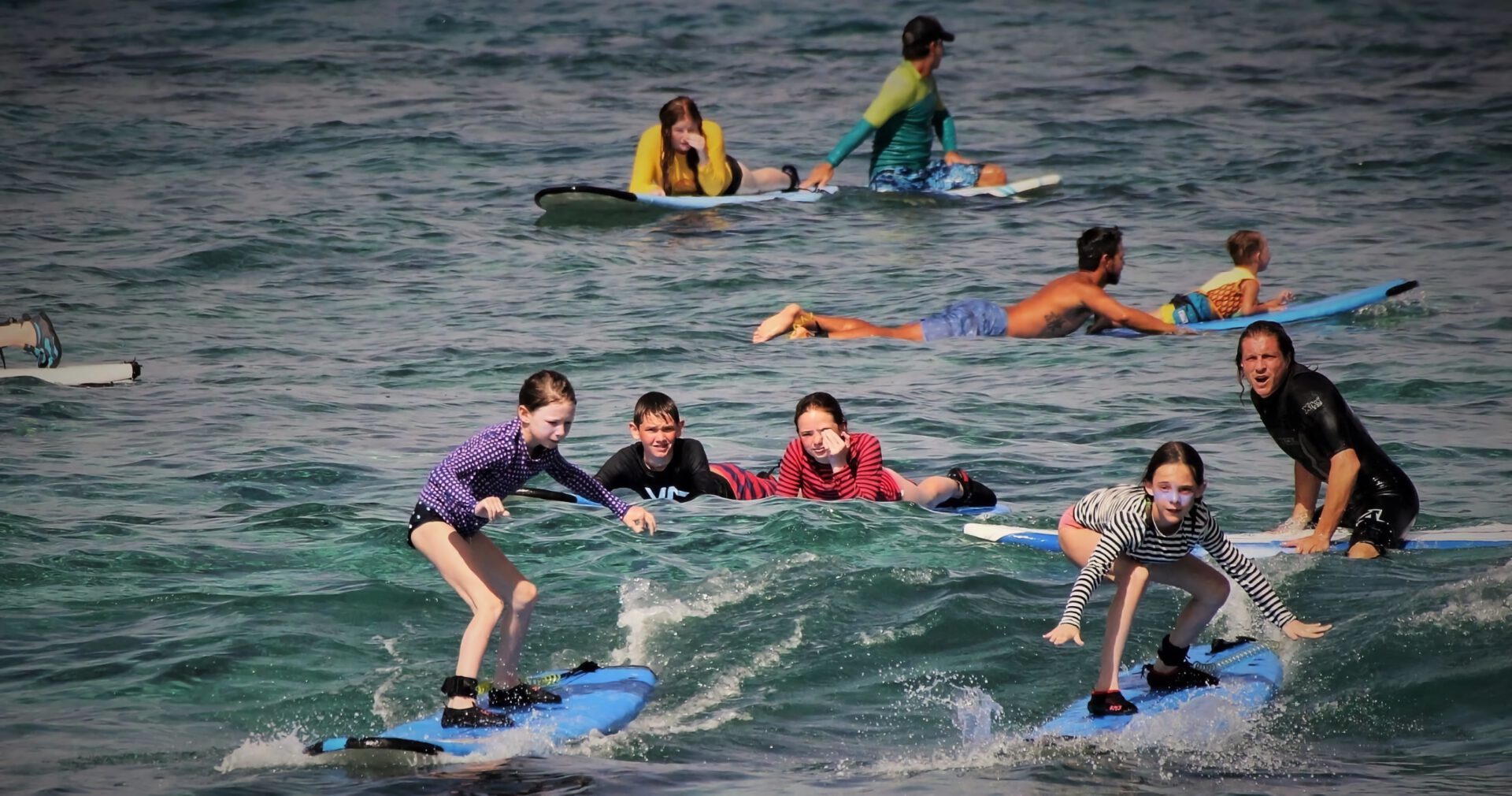 children learning how to surf in hawaii in group lessons