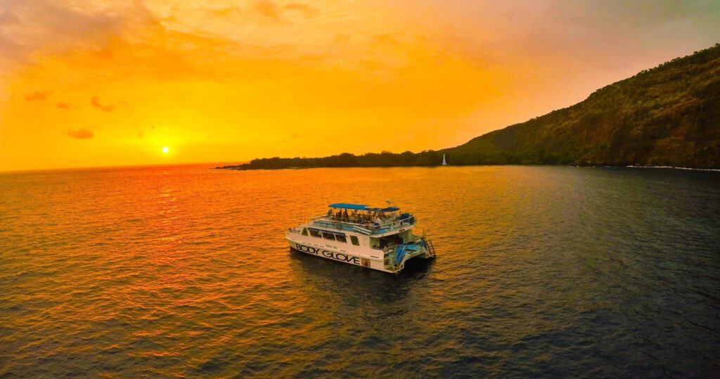 a boat on the ocean during sunset in hawaii