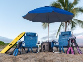 a group of lawn chairs sitting on a chair with a blue umbrella