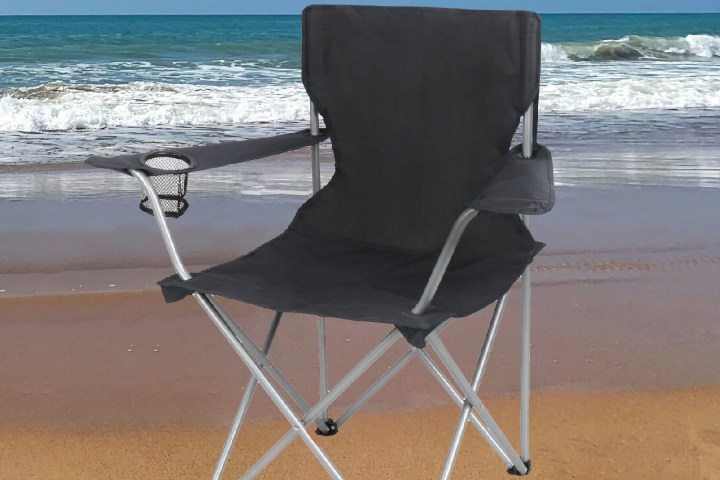 a chair sitting in front of a beach next to the ocean