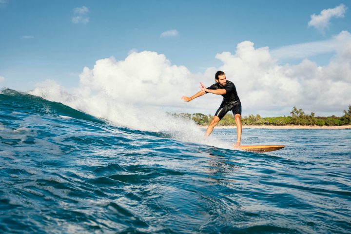 a man riding a wave on a surf board on a body of water