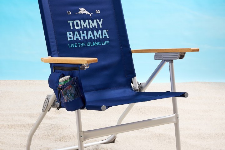 Blue Tommy Bahama beach chair on sand with a drink holder.