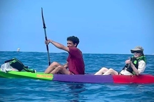 a man riding on the back of a boat in the water